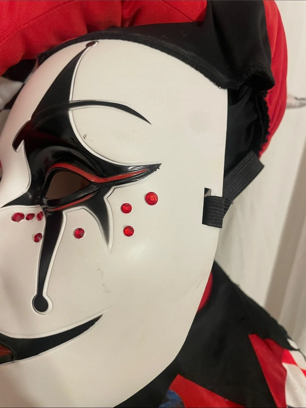 Dirty, scary Jack-in-box Halloween costume or cosplay, including jeweled mask.